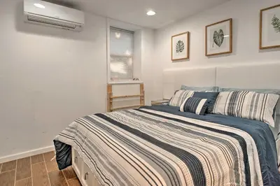 a bedroom with a bed with a striped blanket at Hot Tub and Fire Pit Waterfront Lake Harmony Home in Lake Harmony