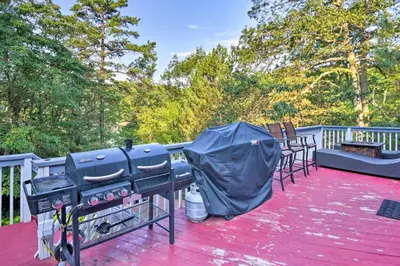 a grill on a deck with chairs and trees at Hot Tub and Fire Pit Waterfront Lake Harmony Home in Lake Harmony