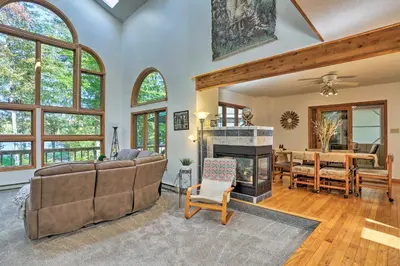 a living room with a couch and a fireplace at Pocono Lake Paradise with Private Beach and Dock! in Pocono Lake