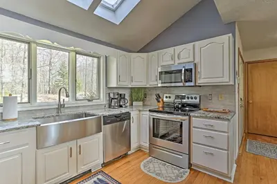 a kitchen with white cabinets and stainless steel appliances at Pocono Lake Paradise with Private Beach and Dock! in Pocono Lake