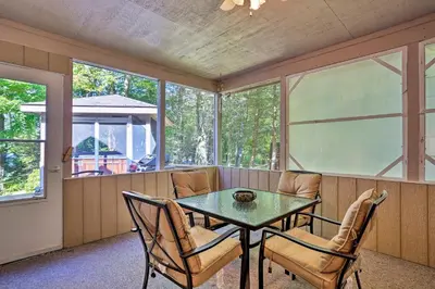 a screened in porch with a table and chairs at Pocono Lake Paradise with Private Beach and Dock! in Pocono Lake