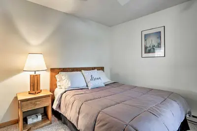 a bedroom with a bed and a lamp on a night stand at Pocono Lake Paradise with Private Beach and Dock! in Pocono Lake