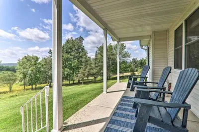 a porch with blue chairs on a house at Private Dog-Friendly Home 3 Mi to Elk Mountain in Union Dale