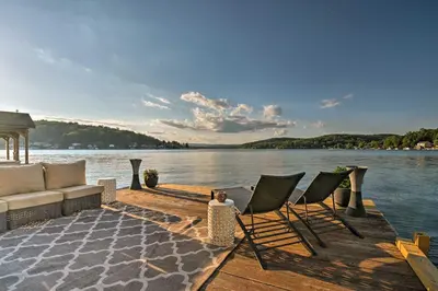 a dock with chairs and a couch on the water at Waterfront Harveys Lake House with Private Dock! in Harveys Lake