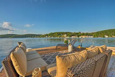 a boat with couches and chairs on a body of water at Waterfront Harveys Lake House with Private Dock! in Harveys Lake