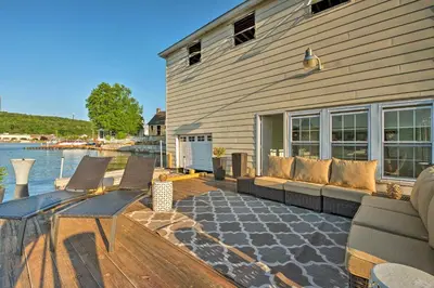 a wooden deck with chairs and a house with the water at Waterfront Harveys Lake House with Private Dock! in Harveys Lake