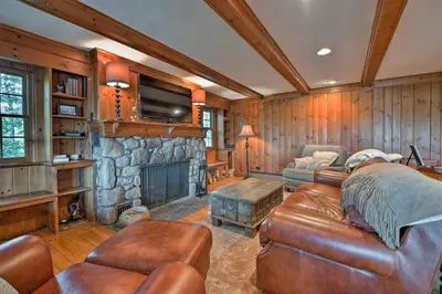 a living room with a couch and a stone fireplace at Waterfront Harveys Lake House with Private Dock! in Harveys Lake