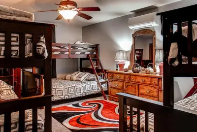 a bedroom with bunk beds and a dresser and a mirror at Lake Harmony Vacation Rental with Hot Tub and Views! in Lake Harmony