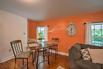 a dining room with a table and a clock on the wall at Cottage with Hot Tub and Fire Pit By Mahantango Creek in Dalmatia