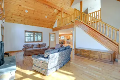 a living room with a staircase and a couch at Benton Home on 50 Acres with Private Deck and Views! in Benton