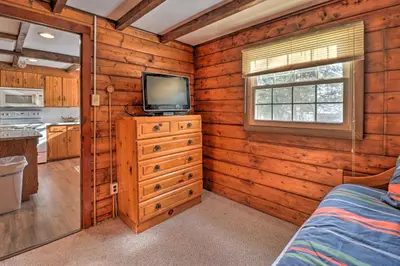 a bedroom with a television and a dresser with a bed at 3 Mi to Slopes! Hot Tub Haven Near Lake Harmony in Lake Harmony