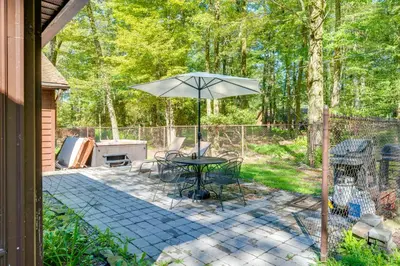 a patio with a table and an umbrella at 3 Mi to Slopes! Hot Tub Haven Near Lake Harmony in Lake Harmony