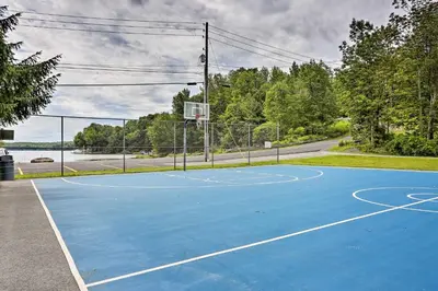 a blue tennis court with a basketball hoop at Mountain Cabin with Deck Near Year-Round Recreation! in Lake Ariel