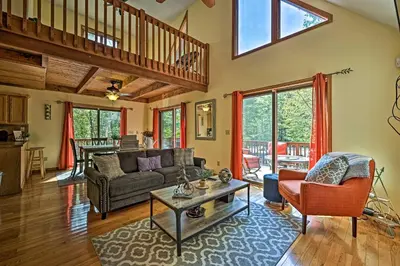 a living room with a couch and a table at Mountain Cabin with Deck Near Year-Round Recreation! in Lake Ariel