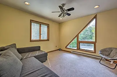a living room with a couch and a ceiling fan at Mountain Cabin with Deck Near Year-Round Recreation! in Lake Ariel