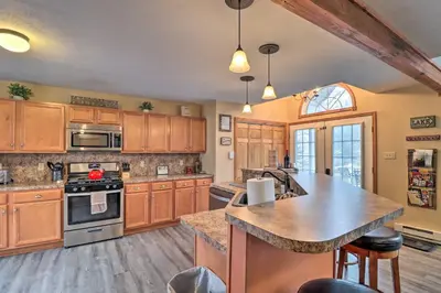 a kitchen with wooden cabinets and a large island in it at Near Lake and Hiking Pocono Home with Hot Tub in Albrightsville