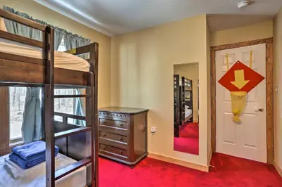 a bedroom with bunk beds and a door with a mirror at Cozy Retreat with Deck and Hot Tub, 20 mins to Kalahari in Tobyhanna