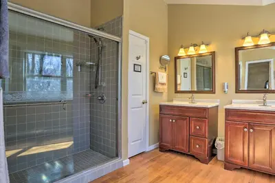 a bathroom with a shower and two sinks at Cozy Retreat with Deck and Hot Tub, 20 mins to Kalahari in Tobyhanna