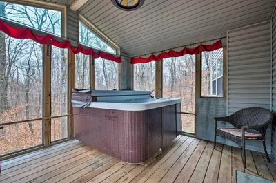 a screened in porch with a hot tub in the middle at Cozy Retreat with Deck and Hot Tub, 20 mins to Kalahari in Tobyhanna