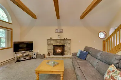 a living room with a couch and a fireplace at Deck and Resort Amenities Arrowhead Lake Home! in Pocono Lake