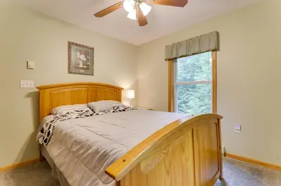 a bedroom with a bed with a ceiling fan and a window at Deck and Resort Amenities Arrowhead Lake Home! in Pocono Lake