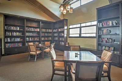 a library with tables and chairs and shelves of books at Deck and Resort Amenities Arrowhead Lake Home! in Pocono Lake