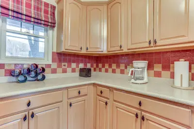 a kitchen with wooden cabinets and a counter top at Spacious Condo with View Less Than 1 Mi to Mtn Creek Resort! in Vernon Township