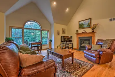 a living room with leather furniture and a fireplace at Pocono Mountain Home with 3 Community Lakes! in Gouldsboro