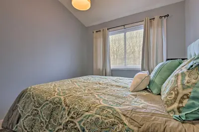 a bedroom with a bed with a comforter and a window at Near Mt Airy Casino Mount Pocono Condo with Balcony in Mount Pocono