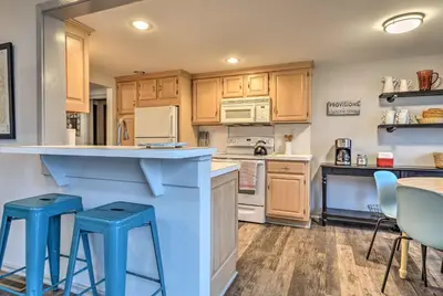 a kitchen with wooden cabinets and blue stools at By Mtn Creek Resort The Point on Highland Lake in Highland Lakes