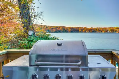 a grill sitting on a table next to a lake at By Mtn Creek Resort The Point on Highland Lake in Highland Lakes