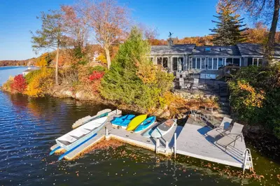 a boat on the water in front of a house at By Mtn Creek Resort The Point on Highland Lake in Highland Lakes