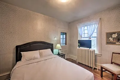 a bedroom with a bed and a television and a chair at 2 Mi to Reading Pagoda Spacious Home with Deck! in Reading