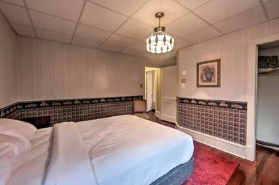 a bedroom with a large bed and a chandelier at 2 Mi to Reading Pagoda Spacious Home with Deck! in Reading
