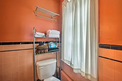 a bathroom with a toilet and a window at Walk to Shops, Dining and City Park Reading Apt in Reading