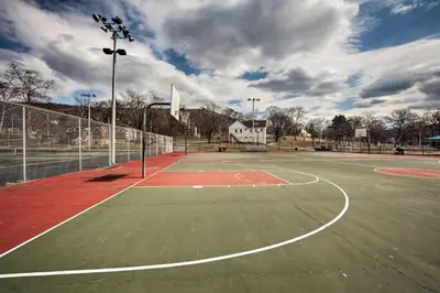 an empty tennis court with a basketball hoop at Walk to Shops, Dining and City Park Reading Apt in Reading