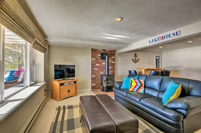 a living room with a leather couch and a tv at Waterfront Pocono Lake Home with Private Dock! in Pocono Lake