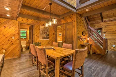 a dining room with a wooden table and chairs at Pocono Log Cabin Fireplace, Fire Pits and Amenities in Pocono Lake