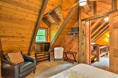 a room with a bed in a cabin with wooden walls at Pocono Log Cabin Fireplace, Fire Pits and Amenities in Pocono Lake