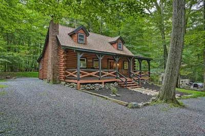 a log cabin in the middle of the woods at Pocono Log Cabin Fireplace, Fire Pits and Amenities in Pocono Lake