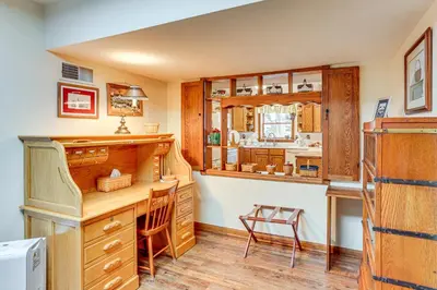 a kitchen with wooden cabinets and a desk at Charming Apartment with Yard and Beautiful Gardens! in Manheim