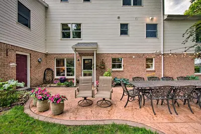 a patio with a table and chairs in front of a house at Charming Apartment with Yard and Beautiful Gardens! in Manheim