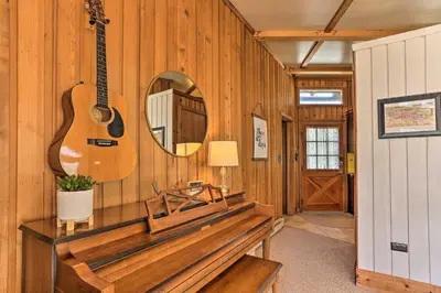 a room with a guitar on the wall and a mirror at Walk to Big Bass Lake Family Home with Deck! in Gouldsboro