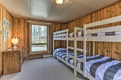 a bedroom with two bunk beds and a window at Walk to Big Bass Lake Family Home with Deck! in Gouldsboro