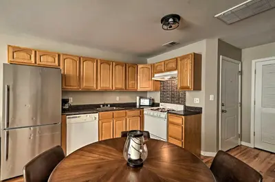 a kitchen with wooden cabinets and a wooden table at Modern Elizabeth Apt by Dining and NYC Transit! in Elizabeth