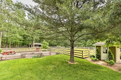 a tree in a yard next to a fence at Family Home with WiFi, 14 Mi to Dutch Wonderland! in New Holland