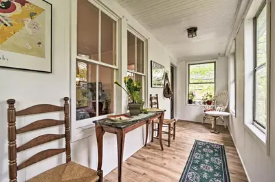 a hallway with a table and some windows at Millburn House with Deck - Walk to NYC Transit! in Millburn