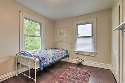 a bedroom with a bed and two windows at Millburn House with Deck - Walk to NYC Transit! in Millburn