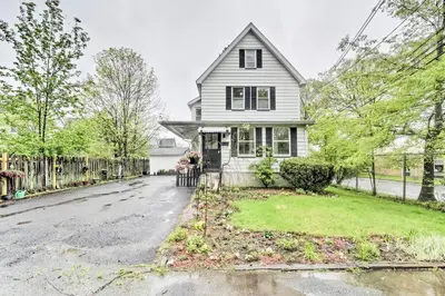 a white house with a fence on a street at Millburn House with Deck - Walk to NYC Transit! in Millburn