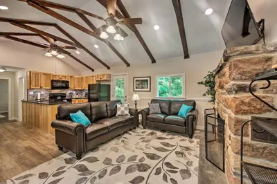a living room with two leather couches and a stone fireplace at Hike, Hunt and Unwind Cozy Cabin Near Hersheypark in Jonestown